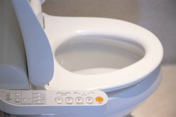 Close-up of a modern bidet toilet seat with control panel for elderly hygiene and health